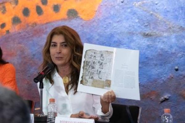 Historian María Castañeda de La Paz with a book of research on the Codices of San Andrés Tetepilco.
