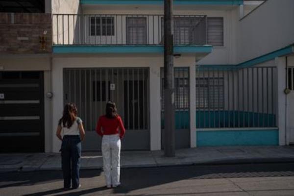 Two young activists in front of the house wher<em></em>e false feminist organizations operated, in Orizaba, Mexico, in December 2023. 